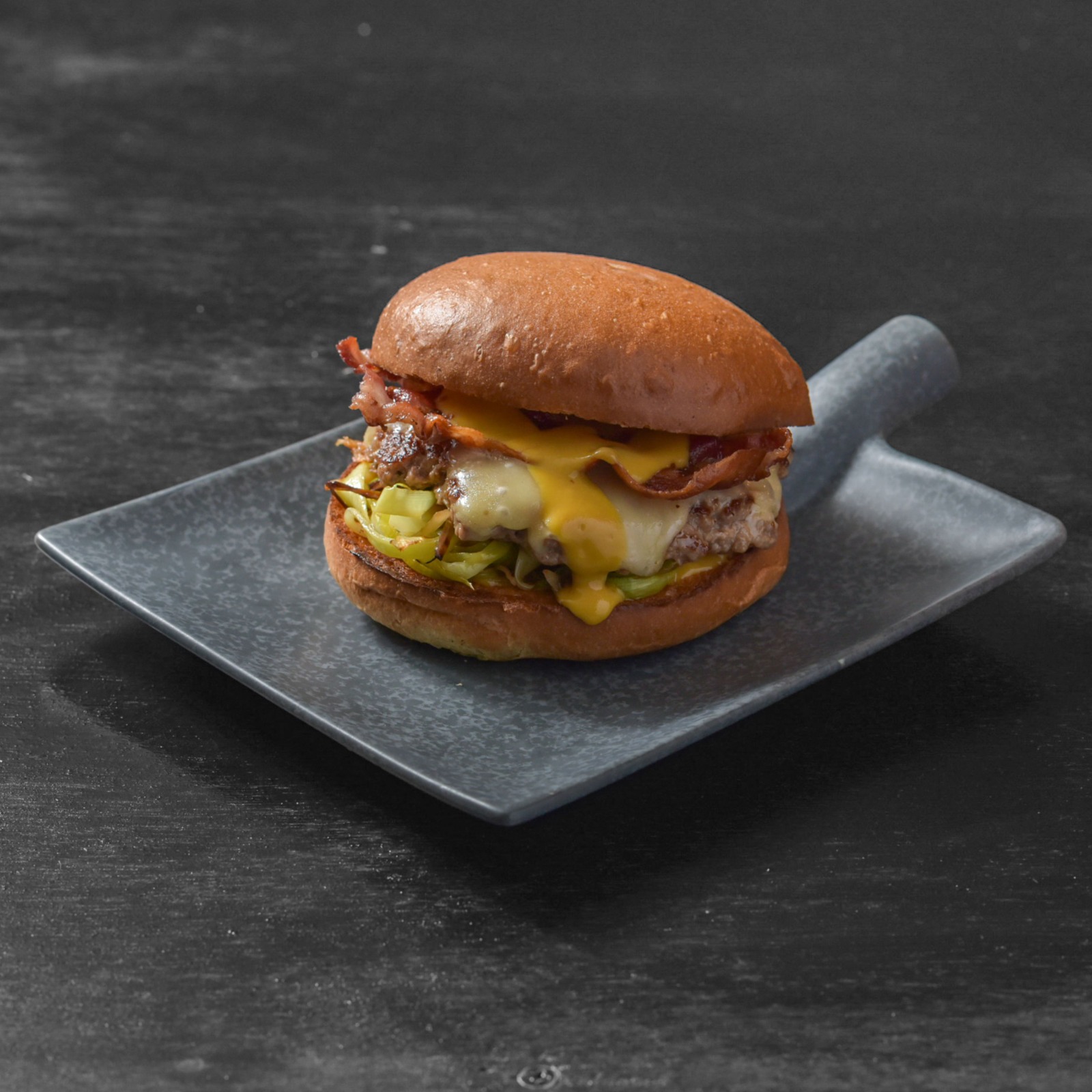 Smash burger con cheddar fuso e bacon croccante servito da Bunker Pescara